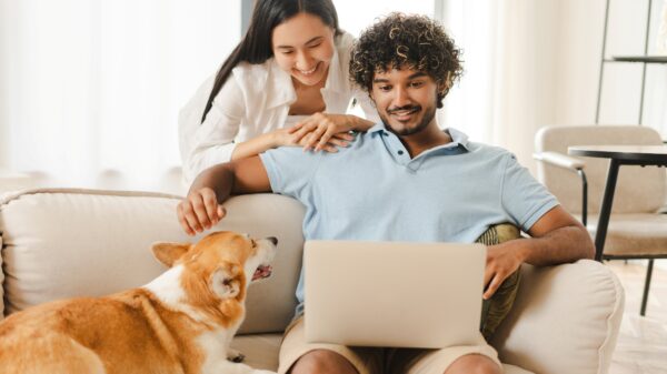A couple with their dog looking at their laptop