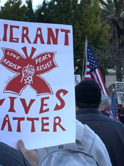 Rally sign that says "migrant lives matter"