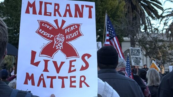 Rally sign that says "migrant lives matter"
