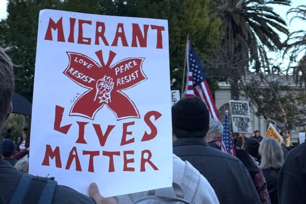 Rally sign that says "migrant lives matter"