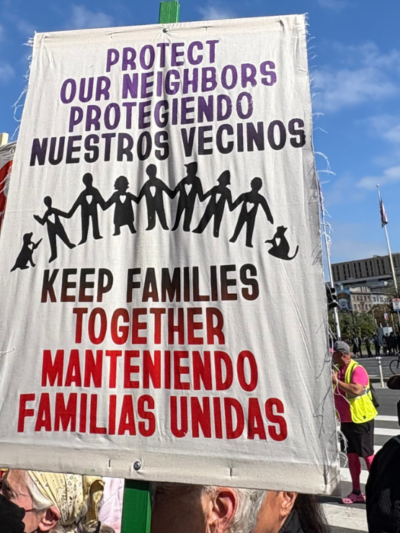 A protest sign reading, "Protect our neighbors, keep families together."