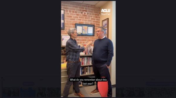 screenshot of video showing two people talking in an office