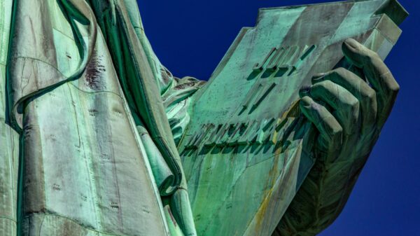 Photo of the hand of the Statue of Liberty holding the book of the American Declaration of Independence