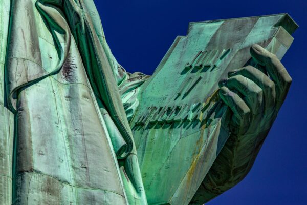 Photo of the hand of the Statue of Liberty holding the book of the American Declaration of Independence