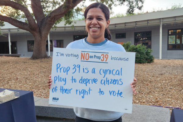Person holding a sign that says "I'm voting No on Prop 39 because Prop 39 is a cynical ploy to deprive citizens of their right to vote.