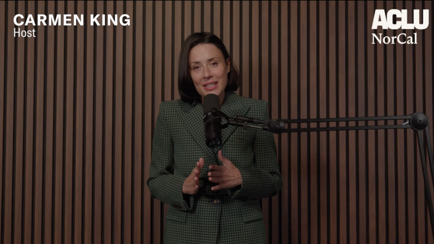 screenshot from podcast of host standing in front of a microphone